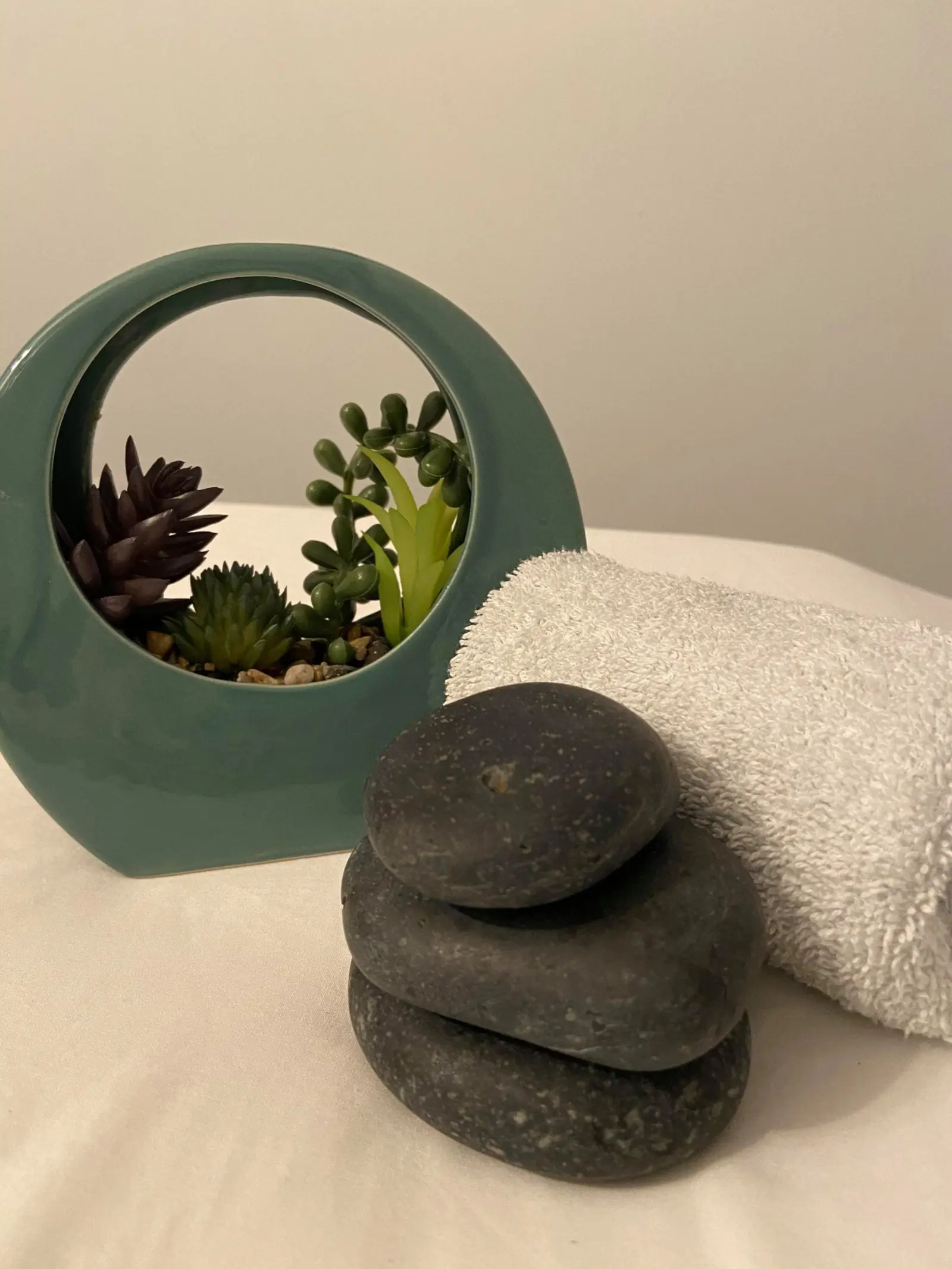 Spa stones with towel and greenery at Rejuvenations Wellness in Langford BC